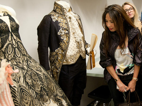 Museum visitors looking at a fashion piece